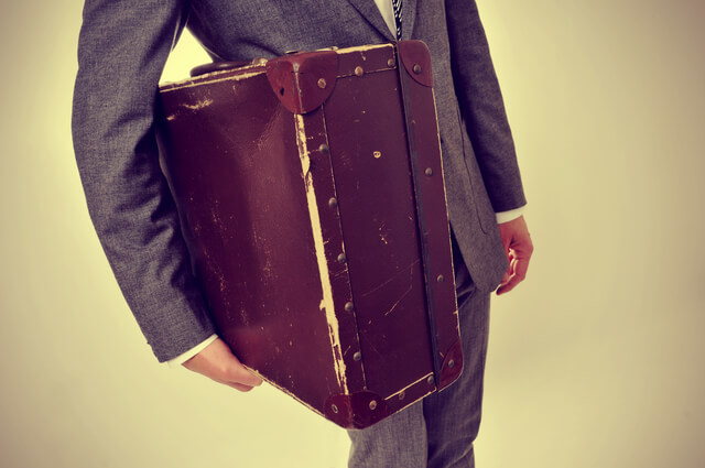 man in suit with an old suitcase